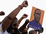 People raise their fists and hold a portrait of George Floyd during a rally following the guilty verdict of the trial of Derek Chauvin on April 20, 2021, in Atlanta, Georgia. (Elijah Nouvelage / AFP)