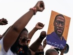 People raise their fists and hold a portrait of George Floyd during a rally following the guilty verdict of the trial of Derek Chauvin on April 20, 2021, in Atlanta, Georgia. (Elijah Nouvelage / AFP) People raise their fists and hold a portrait of George Floyd during a rally following the guilty verdict of the trial of Derek Chauvin on April 20, 2021, in Atlanta, Georgia. (Elijah Nouvelage / AFP)