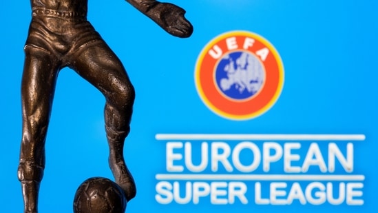 A metal figure of a football player with a ball is seen in front of the words "European Super League" and the UEFA logo in this illustration taken April 20, 2021. (REUTERS)