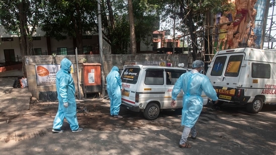 Workers in PPE kits take a dead body out of an ambulance of Covid-19 victim for cremation at Yerwada crematorium in Pune, India, on Monday, April 19, 2021. (Pratham Gokhale / HT Photo)