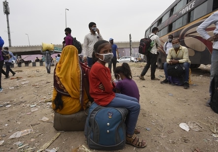 Migrant workers wait for public transport to their native places amid fears of total lockdown due to the sharp spike in coronavirus cases, at Rajiv Chowk Bus Stand, in Gurugram. (Vipin Kumar / Hindustan Times)