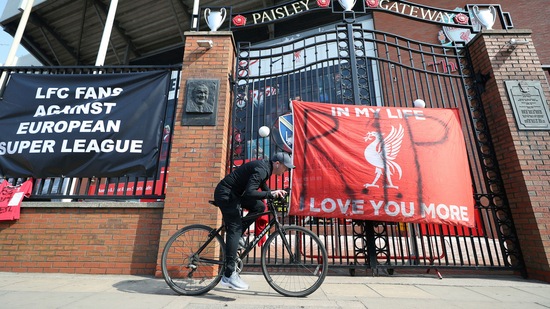 A man cycles past banners outside of Anfield Stadium, Liverpool, England protesting against the clubs decision to join the European Super Leaguer, Tuesday April 20, 2021.(AP)