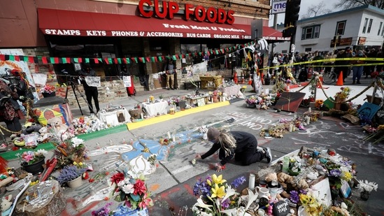 A person places flowers at the George Floyd Square after the announcement of the verdict in Minneapolis on April 20. At George Floyd Square, the intersection where Floyd was killed and which was later named in his honor, people screamed, applauded and some threw dollar bills in the air in celebration.(Octavio Jones / REUTERS)