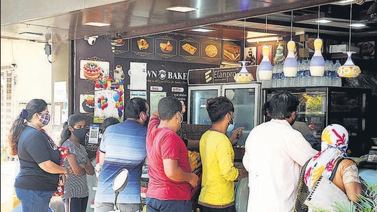 Residents on Tuesday anticipated the 11am deadline and rushed to this bakery in Karvenagar to stock up on items like bread and bakery products. (HT PHOTO)