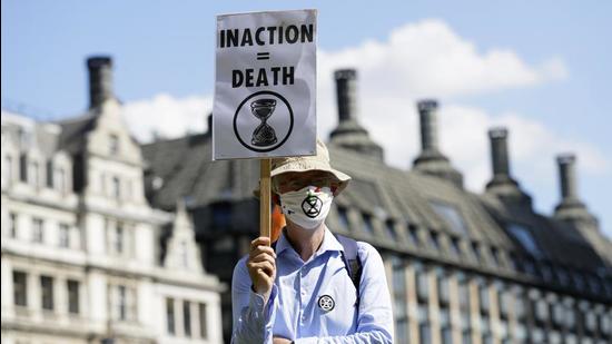 A file photo of a demonstrator holding a poster during an Extinction Rebellion climate change protest in London. (AP) A file photo of a demonstrator holding a poster during an Extinction Rebellion climate change protest in London. (AP)