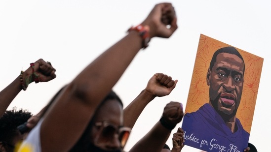 People raise their fists and hold a portrait of George Floyd during a rally following the guilty verdict of the trial of Derek Chauvin on April 20, 2021, in Atlanta, Georgia. (Elijah Nouvelage / AFP)