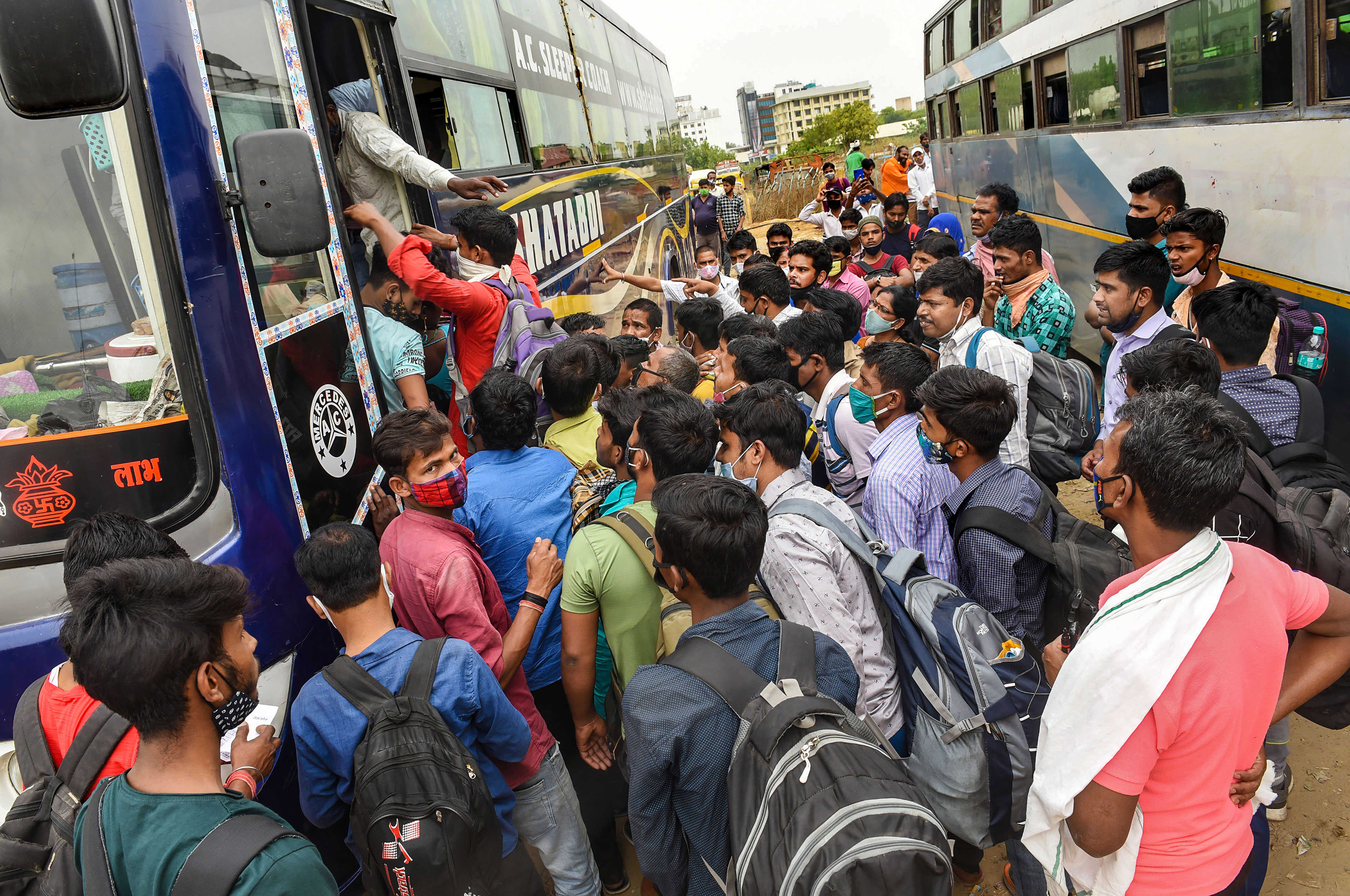 Migrants board interstate buses for their native places, amid a Covid-induced lockdown imposed by Delhi Government to curb coronavirus cases. (PTI) Migrants board interstate buses for their native places, amid a Covid-induced lockdown imposed by Delhi Government to curb coronavirus cases. (PTI)
