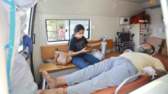 A Covid-19 patient on oxygen support is seen inside an ambulance while waiting for admission amid a shortage of beds at LNJP Hospital, in New Delhi, on April 21. India's daily case tally crossed the 100,000 mark for the first time on April 6 when 115,320 new infections were reported. It just took another nine days for the daily case tally to breach the 200,000 mark as 216,913 new cases were reported on April 15 for the first time, HT reported.(Ajay Aggarwal / HT Photo)