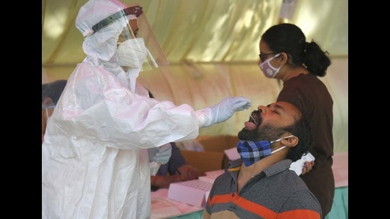 A resident being tested for Covid during a free camp organised by the Sector 44 Market Welfare Association in Chandigarh on Thursday. (Keshav Singh/HT)