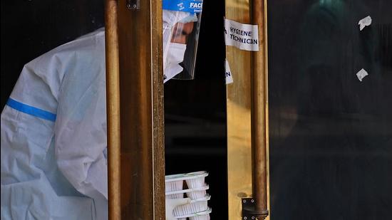 Representational image. A health worker picks up food deliveries at the door of a makeshift Covid-19 quarantine facility. (Bloomberg) Representational image. A health worker picks up food deliveries at the door of a makeshift Covid-19 quarantine facility. (Bloomberg)