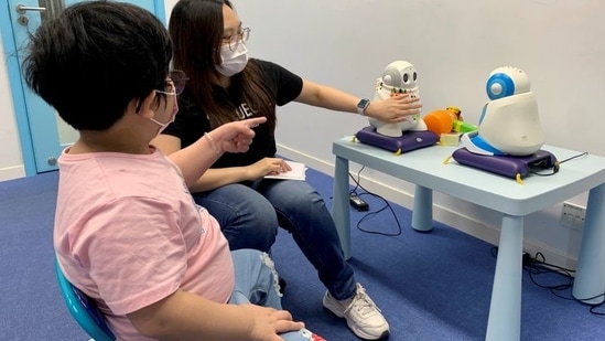 Autism tutor Sarah Ng uses robots to teach a 5-year-old child with special needs to introduce herself.(REUTERS)