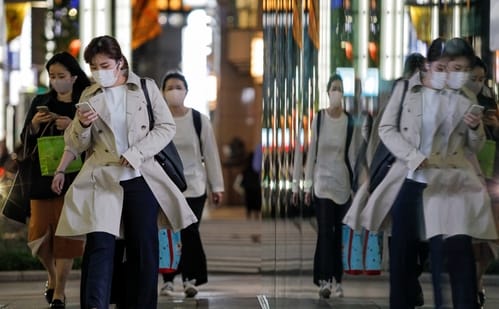 Passersby wearing protective masks walk on the street amid the coronavirus disease (COVID-19) outbreak in Tokyo. ( REUTERS)