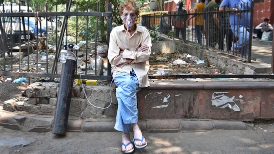 A Covid-19 patient on oxygen support waits outside Lok Nayak Jai Prakash Narayan Hospital (LNJP) for a bed, in New Delhi on April 22. A problem that came into focus early on April 20, when several hospitals in the Capital said they were on the verge of oxygen supplies running out, recurred on April 21 and April 22, with close to 1,000 critically ill patients being in danger on both days.(Ajay Aggarwal / HT Photo)