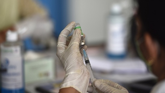 Noida, India - April 23, 2021: A health worker draws a syringe from a Covishield vaccine vial at Bhangel CHC Hospital sector 110, in Noida, India, on Thursday, April 23, 2021. (Sunil Ghosh / Hindustan Times)
