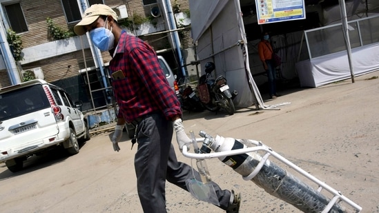 A family member of a Covid-19 patient carries an oxygen cylinder at Nalanda Medical College and Hospital in Patna on Friday. (ANI Photo) A family member of a Covid-19 patient carries an oxygen cylinder at Nalanda Medical College and Hospital in Patna on Friday. (ANI Photo)