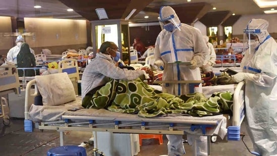 Medical professionals in PPE coveralls tending to a patient at a temporary Covid Care facility in New Delhi.(Ajay Aggarwal / HT Photo) Medical professionals in PPE coveralls tending to a patient at a temporary Covid Care facility in New Delhi.(Ajay Aggarwal / HT Photo)