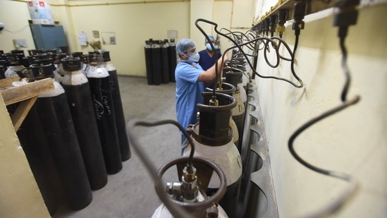 Health workers checking empty oxygen cylinders at in ESIC (Indira Gandhi) Hospital Jhilmil in New Delhi on April 22. The Union government increased Delhi’s quota of daily oxygen supply from 378MT to 480MT on April 21, but officials said even this may not be adequate and the additional capacity was likely to take time to arrive.(Raj K Raj / HT Photo)