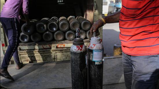 Workers load refilled oxygen tanks into a vehicle at a refill station in Navi Mumbai, India, on Thursday. (Bloomberg) Workers load refilled oxygen tanks into a vehicle at a refill station in Navi Mumbai, India, on Thursday. (Bloomberg)