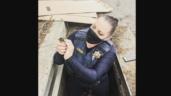 The image shows the officer rescuing a duckling.(Facebook/@HaywardPoliceDept)