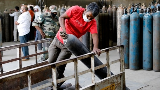 Workers load oxygen cylinders at a charging station on Friday.(AP File Photo ) Workers load oxygen cylinders at a charging station on Friday.(AP File Photo )
