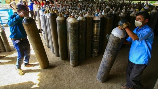 Workers check oxygen cylinders before transporting them to hospitals for Covid-19 patients. Workers check oxygen cylinders before transporting them to hospitals for Covid-19 patients.