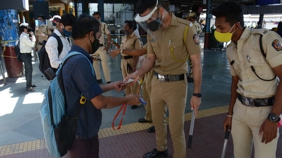 Police personnel checking the ID card of a Mumbai local passenger at Thane station on Friday. (HT/ Praful Gangurde)