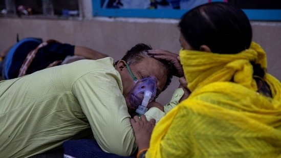 A woman takes care of her husband who is suffering from the coronavirus disease (Covid-19) as he waits to get admitted outside the casualty ward at Guru Teg Bahadur hospital, amidst the spread of the disease in New Delhi, India.(Reuters)