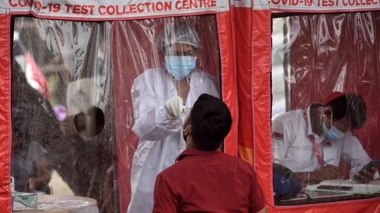 A BMC healthcare worker collecting swab samples from people at a Covid-19 Test Collection Centre in Goregaon, Mumbai on April 23. The rising positivity rate cannot be explained by low testing. Nationally, the seven-day average of daily tests per million residents have risen 53% in the past month – from 766 samples a day per million, to 1,176.(Satish Bate / HT Photo)