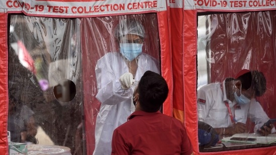 A BMC healthcare worker collects swab samples from people at a Covid-19 test collection centre in Goregaon, Mumbai. (Satish Bate/HT Photo) A BMC healthcare worker collects swab samples from people at a Covid-19 test collection centre in Goregaon, Mumbai. (Satish Bate/HT Photo)