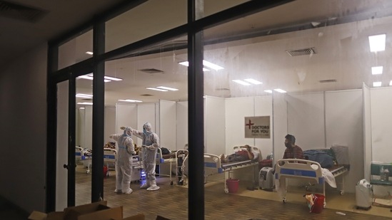 Health workers in full personal protective equipment (PPE) in a Covid-19 hospital set up inside a stadium in New Delhi on April 23. However, the seven-day average of positivity rate is rising in all of India’s 20 most populous regions. Only three of these regions – Assam (3%), Jammu and Kashmir (4.3%) and Telangana (4.4%) – are currently below the World Health Organization’s recommended threshold of 5%.(Anindito Mukherjee / Bloomberg)