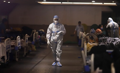A health worker walks through at a makeshift Covid-19 quarantine facility set up at a banquet hall in New Delhi. (Bloomberg) A health worker walks through at a makeshift Covid-19 quarantine facility set up at a banquet hall in New Delhi. (Bloomberg)