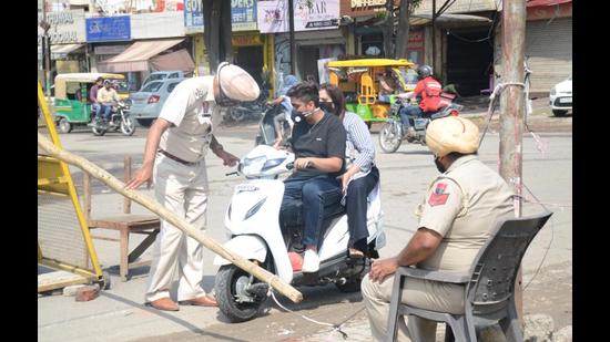 Police stopping the entry of commuters in Dugri’s Urban Estate, which is under lockdown. (Gurpreet Singh/HT)