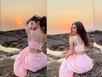 Mouni Roy lounges on the sea rocks in baby pink bralette top, pattern-cut skirt(Instagram/imouniroy)