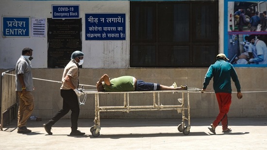 Relatives move a Covid-19 patient on a stretcher at GTB Hospital, in New Delhi, on April 24. An unprecedented spike in Covid-19 cases in Delhi in its fourth wave – the worst so far – pushed the number of total infections in the national capital past the one million mark on April 24.(Amal KS / HT Photo)