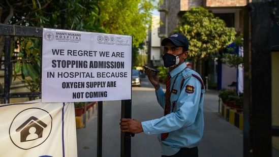 A security personnel seen next to a board notifying shortage of oxygen beds at Shanti Mukund Hospital, in New Delhi, on April 22. The latest 250,000 cases were recorded in just 11 days as Delhi’s health care infrastructure creaked under the massive caseload and hospitals made urgent appeals for life-saving supplies.(Amal KS / HT Photo)