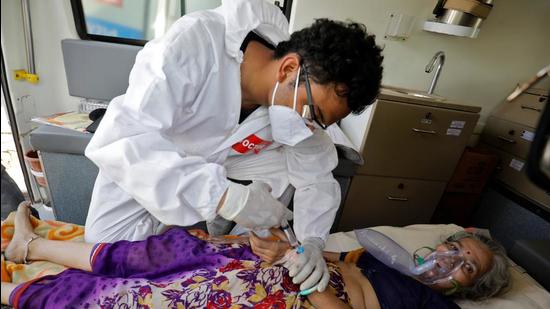 A doctor tends to a patient with a breathing problem inside an ambulance waiting to enter a Covid-19 hospital for treatment, in Ahmedabad, India, on Sunday. (REUTERS)
