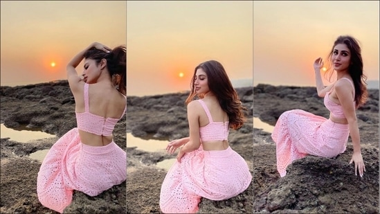 Mouni Roy lounges on the sea rocks in baby pink bralette top