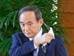 Japanese Prime Minister Yoshihide Suga takes off his face mask before speaking to reporters at his office in Tokyo. Japanese Prime Minister Yoshihide Suga takes off his face mask before speaking to reporters at his office in Tokyo.