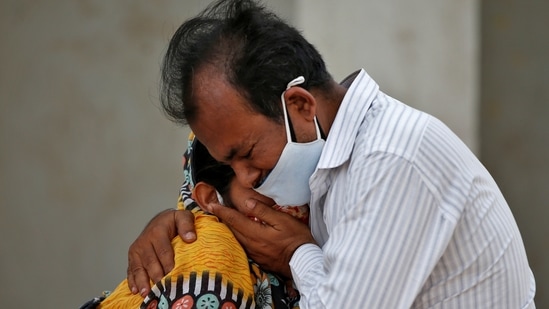 A woman is consoled by her relative after her husband died from the coronavirus disease (Covid-19) outside a Covid-19 hospital in Ahmedabad on April 26. India’s daily count of cases of the coronavirus disease (Covid-19) stayed above 300,000 for the fifth consecutive day, the Union ministry of health and family welfare dashboard showed on April 26 morning.(Amit Dave / REUTERS)