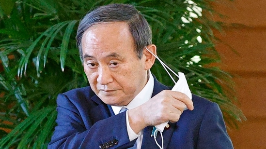 Japanese Prime Minister Yoshihide Suga takes off his face mask before speaking to reporters at his office in Tokyo Monday, April 26, 2021. (AP) Japanese Prime Minister Yoshihide Suga takes off his face mask before speaking to reporters at his office in Tokyo Monday, April 26, 2021. (AP)
