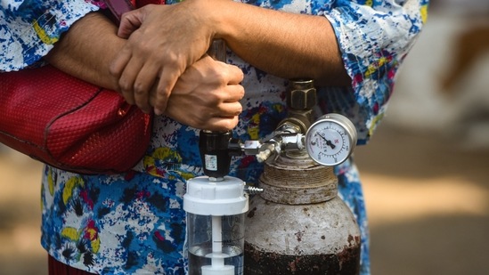 A woman holds onto her personal oxygen cylinder at LNJP Hospital in New Delhi on April 22. Active cases, meanwhile, rose by 130,907 infections to 2,813,658 increasing to 16.25% in the overall caseload.(Amal KS / HT Photo)