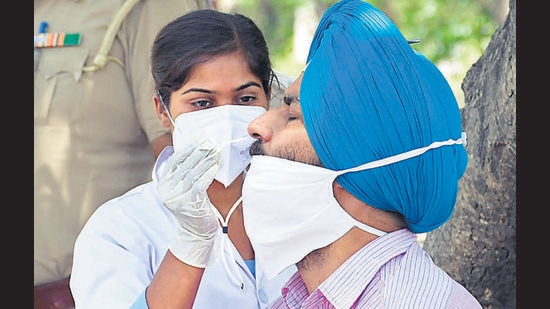 A health worker testing a resident for Covid-19 at a containment zone in Urban Estate, Dugri, in Ludhiana on Monday. (Gurpreet Singh/HT)