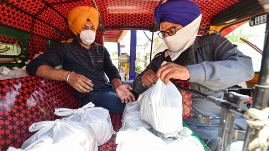 Meals being distributed at the Bangla Sahib Gurdwara, Delhi Sikh Gurdwara Management Committee (DSGMC) is providing cooked meals to Covid-19 patients quarantined at home, in New Delhi, Monday, April 26, 2021. (PTI) Meals being distributed at the Bangla Sahib Gurdwara, Delhi Sikh Gurdwara Management Committee (DSGMC) is providing cooked meals to Covid-19 patients quarantined at home, in New Delhi, Monday, April 26, 2021. (PTI)