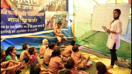 Children study at a temporary school at a protest site during a farmer's protest against the new farm laws, at the Delhi-Ghazipur border in New Delhi. (File photo) Children study at a temporary school at a protest site during a farmer's protest against the new farm laws, at the Delhi-Ghazipur border in New Delhi. (File photo)