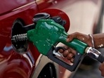A worker holds a nozzle to pump petrol into a vehicle at a fuel station in Mumbai, India.