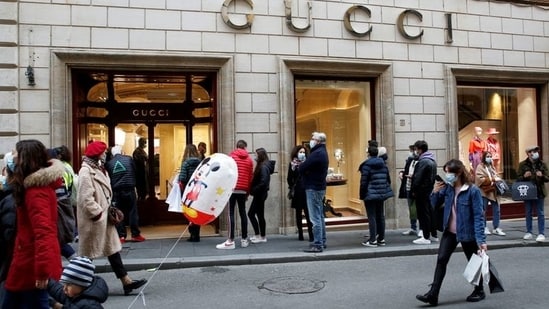 People queue outside a Gucci store on via Condotti in Rome, Italy.(Reuters)