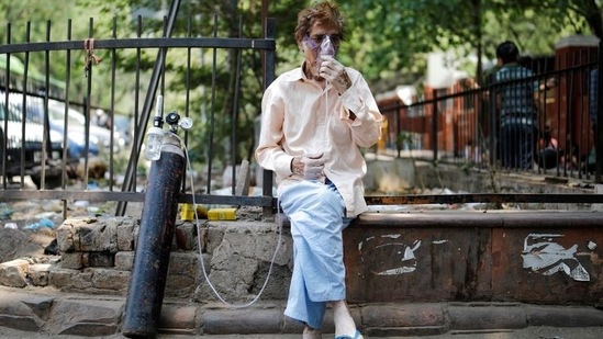 A patient, wearing an oxygen mask, sits outside Lok Nayak Jai Prakash Narayan Hospital (LNJP), one of India's largest facilities for coronavirus disease (Covid-19) patients only, in New Delhi, India, April 22, 2021. (Reuters)