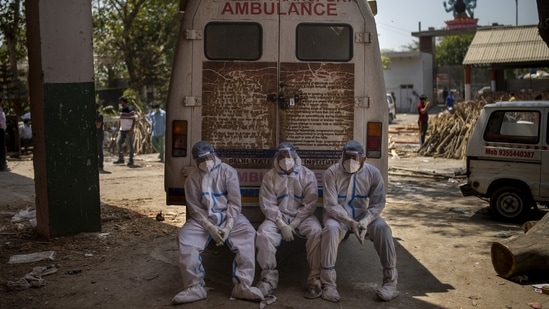 Exhausted workers, who bring dead bodies for cremation, sit on the rear step of an ambulance inside a crematorium, in New Delhi on April 24. "Unfortunately beds do not treat patients - doctors, nurses and paramedics do," Devi Shetty, a cardiac surgeon and chairman of the Narayana Health chain of hospitals, told Reuters. (Altaf Qadri / AP) Exhausted workers, who bring dead bodies for cremation, sit on the rear step of an ambulance inside a crematorium, in New Delhi on April 24. "Unfortunately beds do not treat patients - doctors, nurses and paramedics do," Devi Shetty, a cardiac surgeon and chairman of the Narayana Health chain of hospitals, told Reuters. (Altaf Qadri / AP)