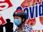 A woman wearing a protective mask drives past a banner promoting prevention against Covid-19 in Hanoi, Vietnam. (Reuters file photo) A woman wearing a protective mask drives past a banner promoting prevention against Covid-19 in Hanoi, Vietnam. (Reuters file photo)