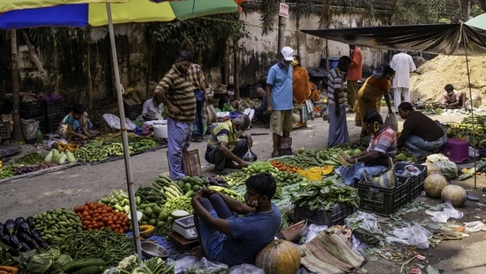 Customers wear protective masks and face coverings while shopping for vegetables from street vendors at a market in the Azadgarh area of Kolkata, India.(Bloomberg) Customers wear protective masks and face coverings while shopping for vegetables from street vendors at a market in the Azadgarh area of Kolkata, India.(Bloomberg)